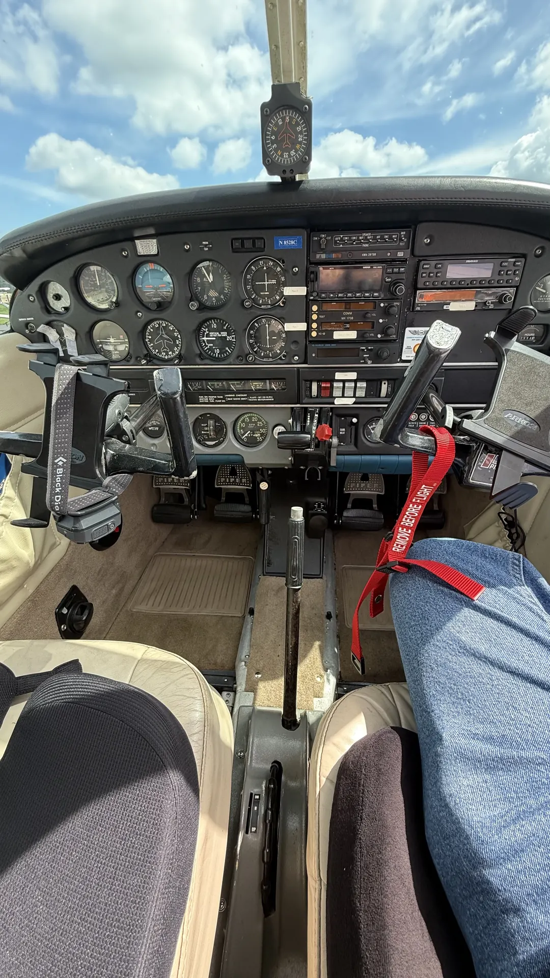 The panel, both control yokes and the rudder pedals, looking forward over the front seats.