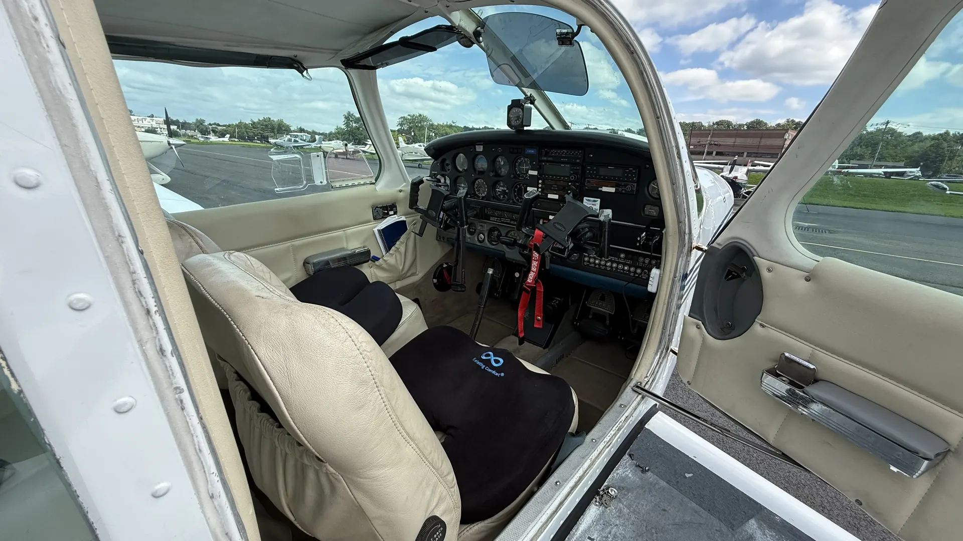 The pilot's seat and panel seen through the open cabin door.