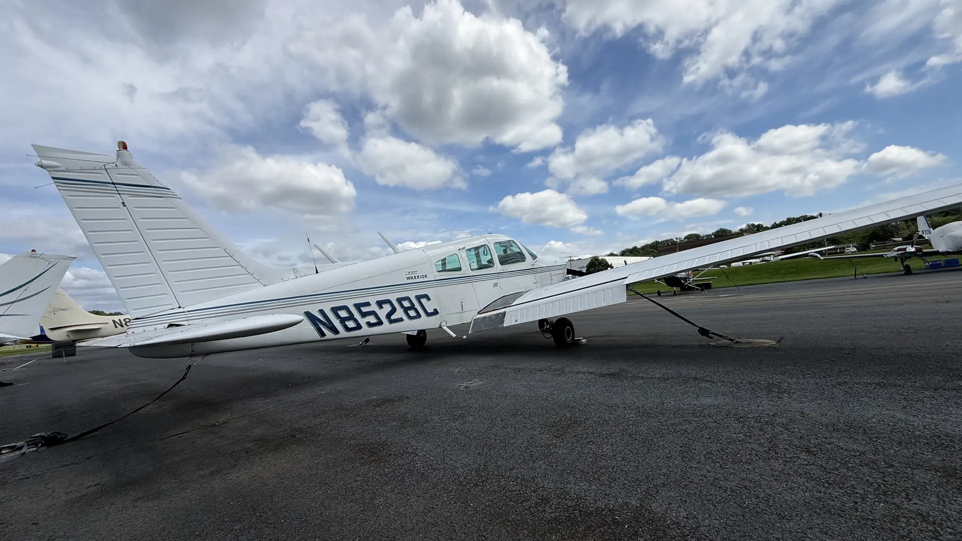 A low view of the Warrior from behind the left wing, looking forward along the fuselage.